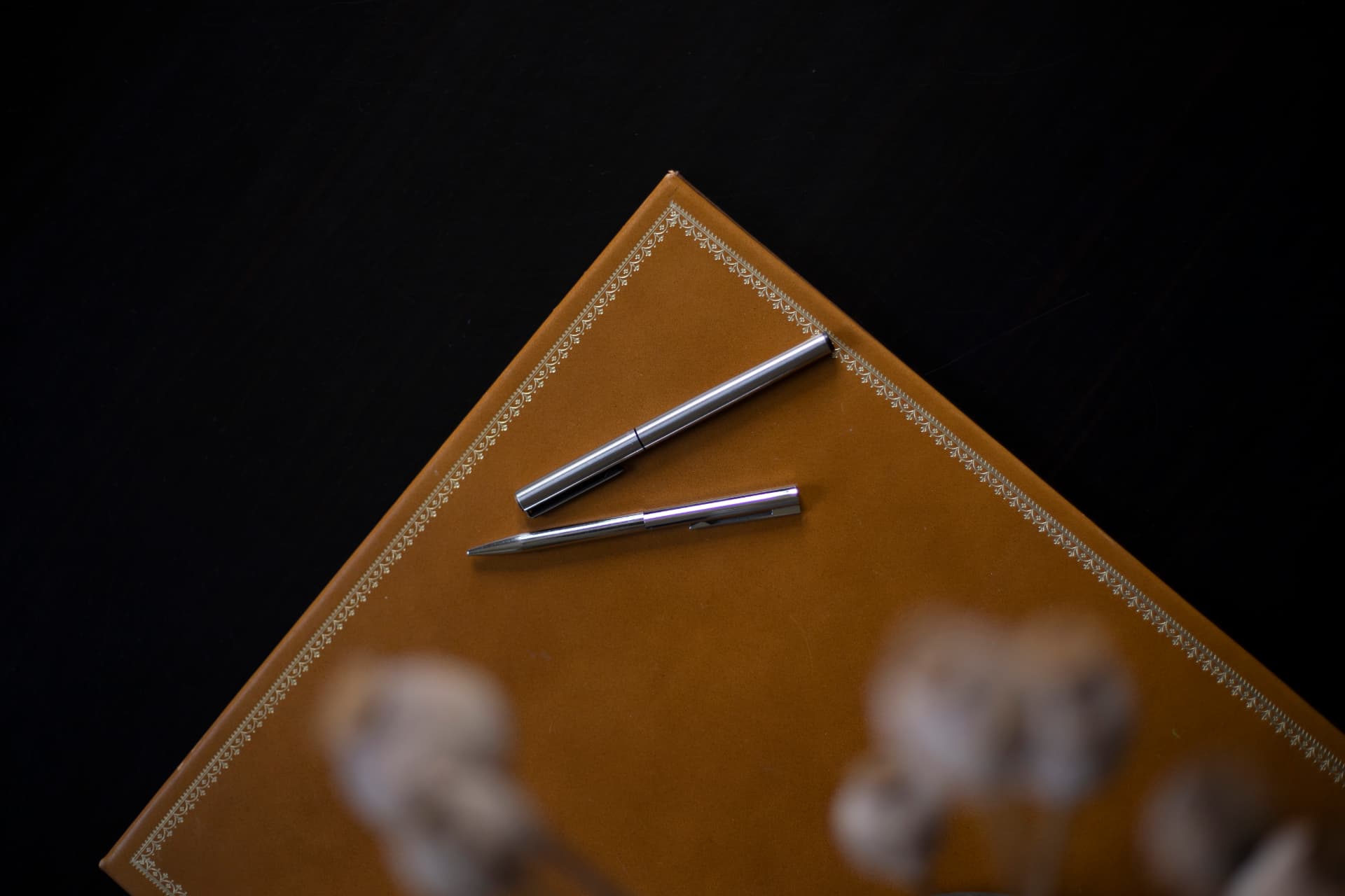 Stylos posés sur un porte-documents en cuir