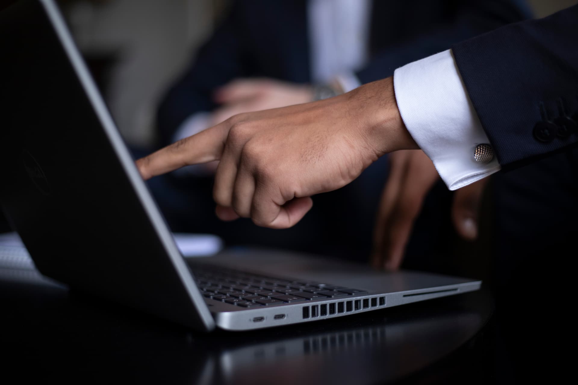 Main pointant un écran d'ordinateur